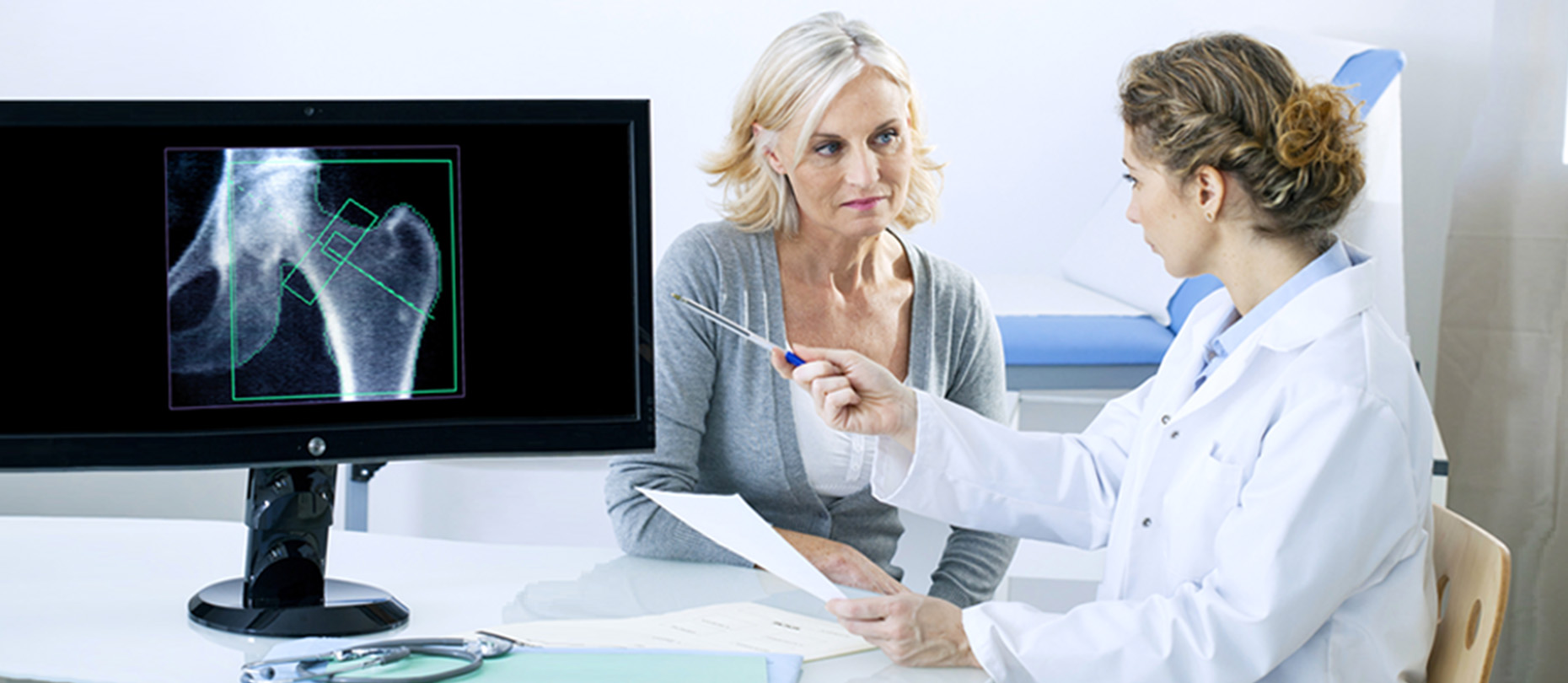 Woman consulting with doctor in office with x-ray of bone