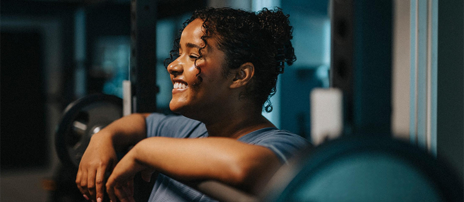 Woman rests on a barbell.