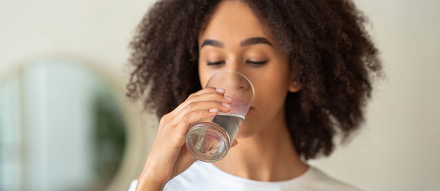 A person drinks a glass of water.