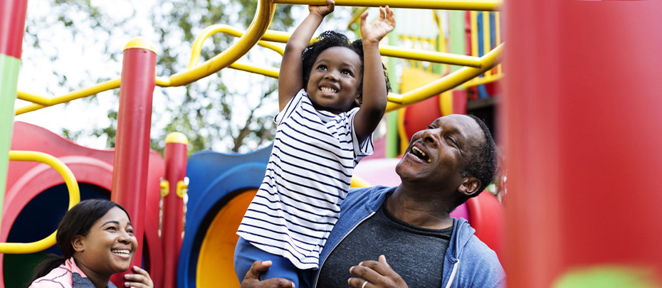 A happy, active family plays at a playground.