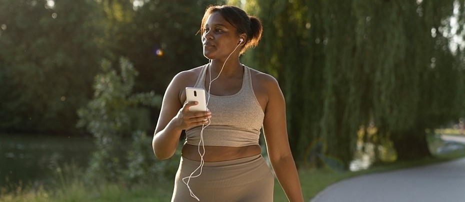 Person holds their phone up as they exercise outdoors