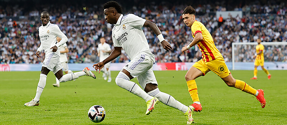 Soccer players in action during a match in a stadium full of fans.