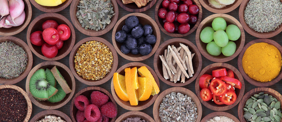 Small circular bowls filled with foods for immune system support, such as garlic, kiwi, ginger, oranges and seeds.