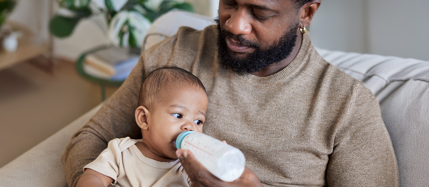 A father feeds his baby a bottle.