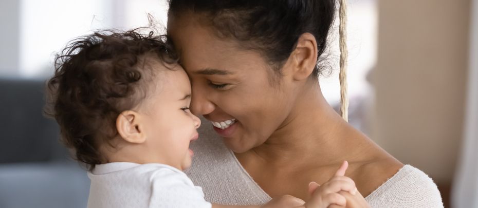 A mother holds a sleeping baby in her arms.